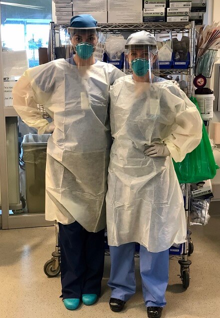 Both nurses stand together in personal protective equipment